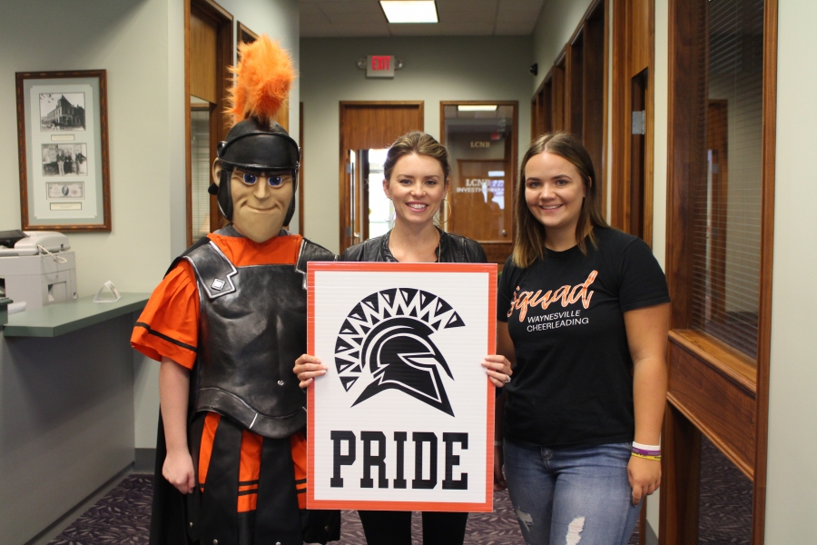 spartan mascot and three people holding a sign